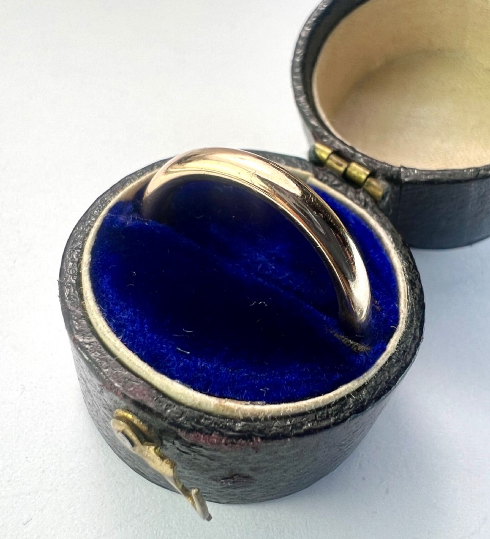A smooth plain 9ct gold ring displaying visible official hallmarks stamped on the interior band. View VI