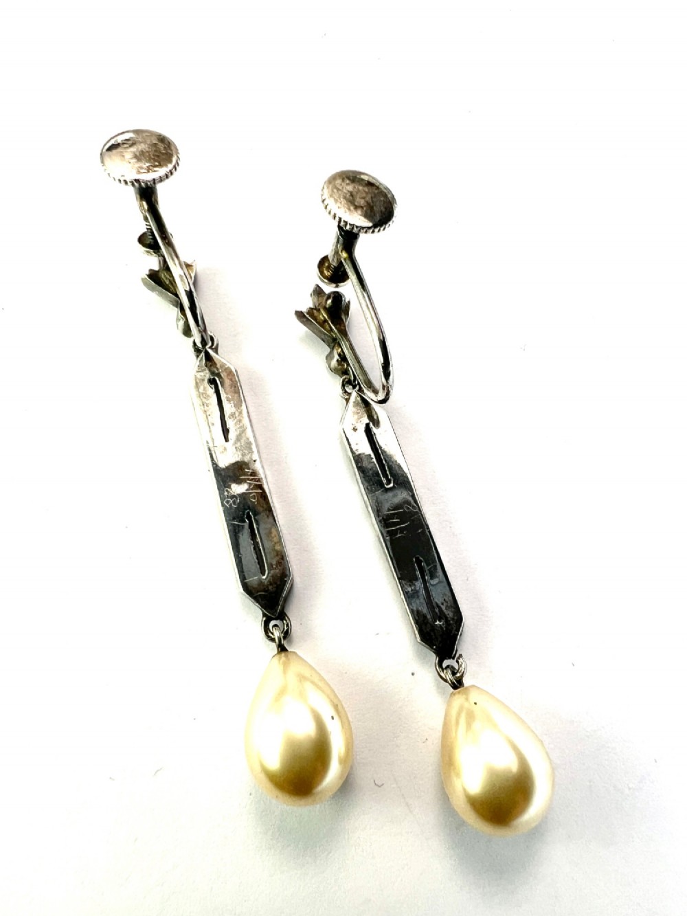 Pair of Art Deco silver drop earrings featuring geometric marcasite-set panels suspended above cream teardrop pearls. View III