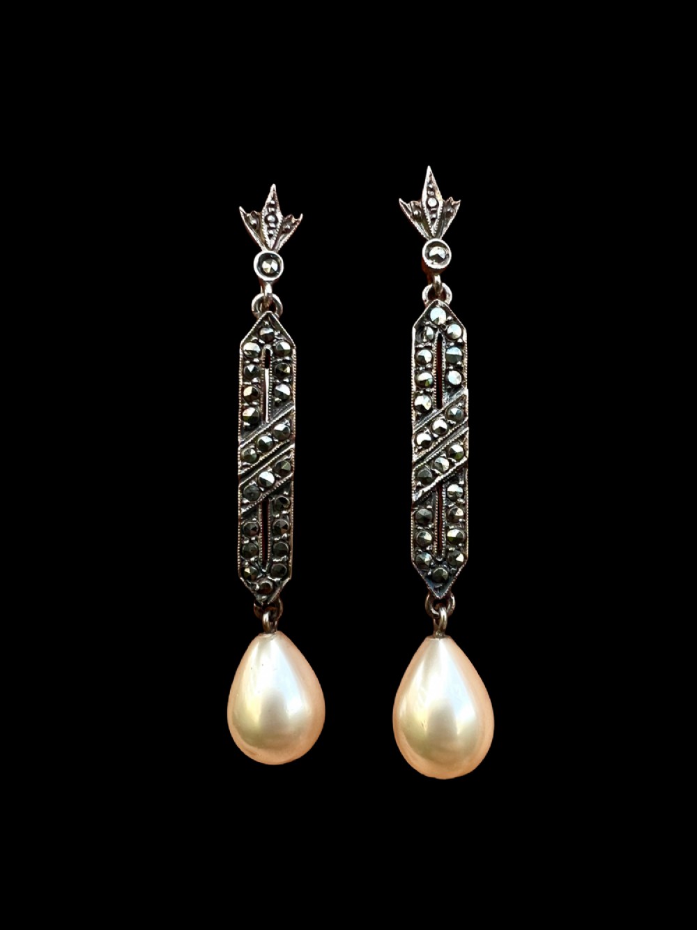 Pair of Art Deco silver drop earrings featuring geometric marcasite-set panels suspended above cream teardrop pearls. View V