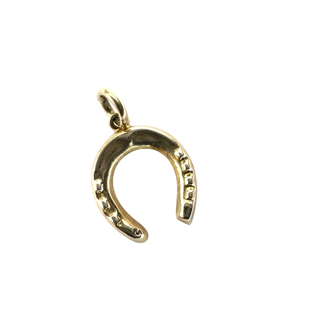 A vintage 9ct yellow gold horseshoe charm pendant featuring realistic nail detail impressions and a top suspension ring.