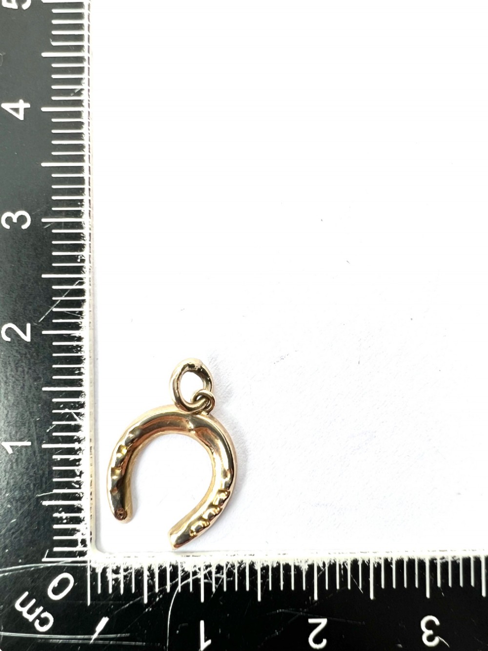 A vintage 9ct yellow gold horseshoe charm pendant featuring realistic nail detail impressions and a top suspension ring. View IV