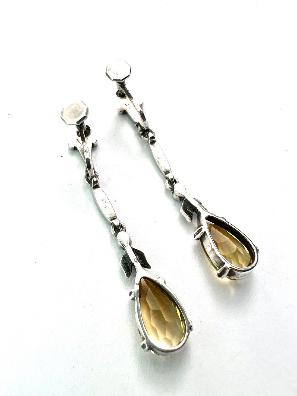 A pair of vintage sterling silver drop earrings featuring faceted teardrop citrine stones suspended from articulated marcasite-set links. View III