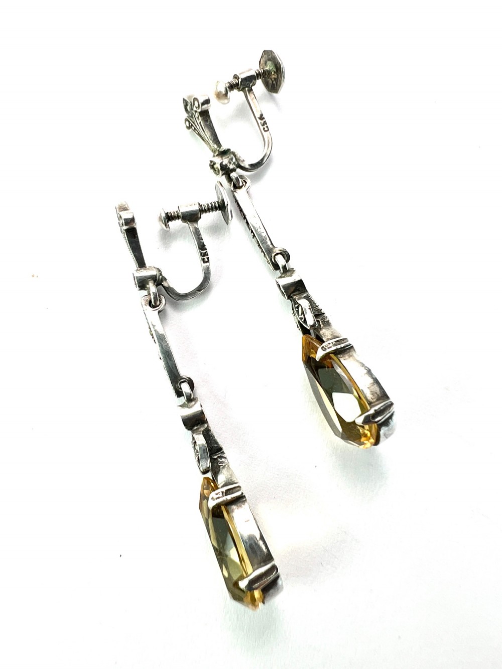 A pair of vintage sterling silver drop earrings featuring faceted teardrop citrine stones suspended from articulated marcasite-set links. View IV