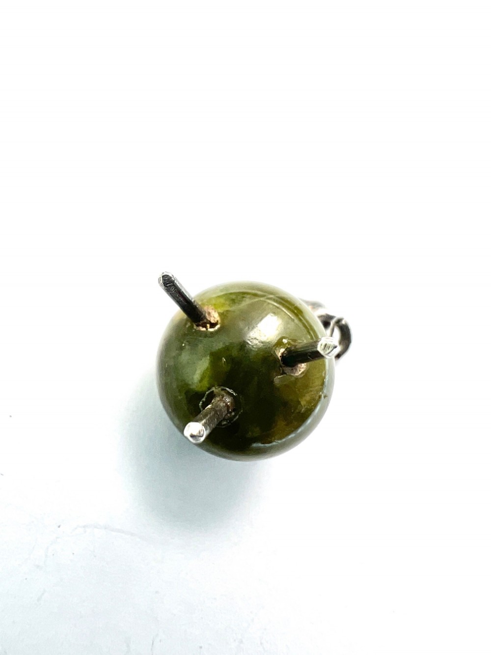 An Edwardian sterling silver and carved green stone cauldron pendant featuring tripod feet, a moveable silver handle, and hallmarked stamp details. View IV