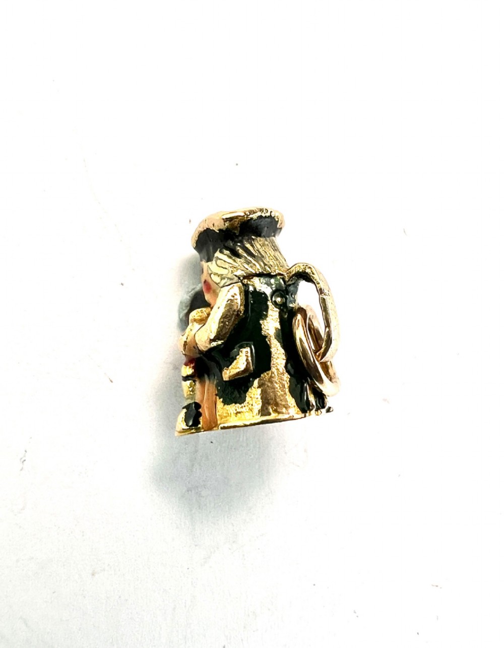 A miniature 9ct gold and enamel Toby jug charm depicting a seated figure in a tricorn hat with red and black painted details. View II