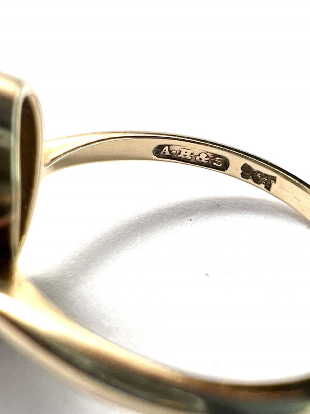 An Edwardian 9ct yellow gold solitaire ring featuring a smooth, oval grey chalcedony cabochon set in a bezel mount. View VII