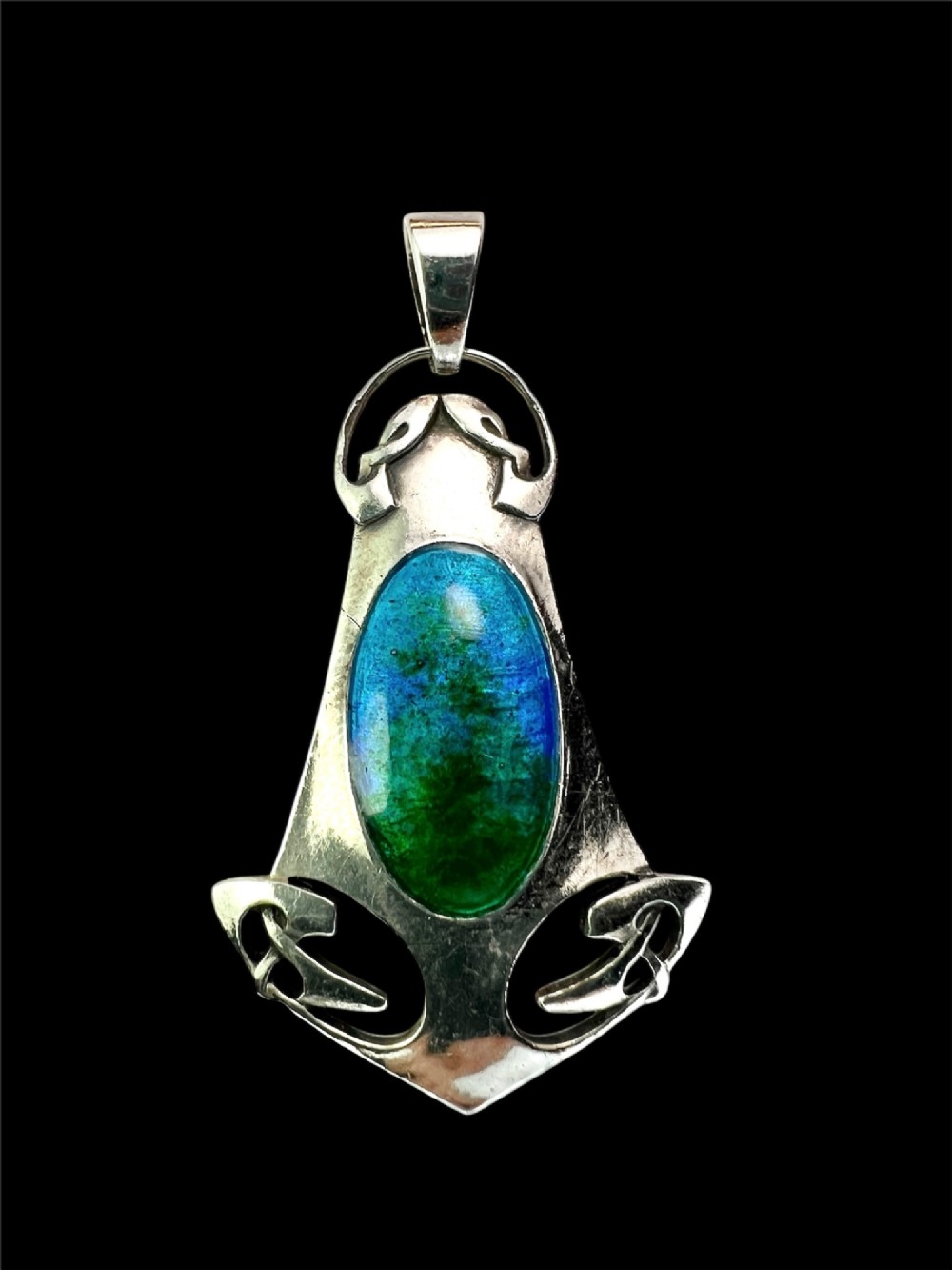 A silver Arts and Crafts style openwork pendant featuring stylised Celtic knots around a central oval blue and green enamel insert. View V