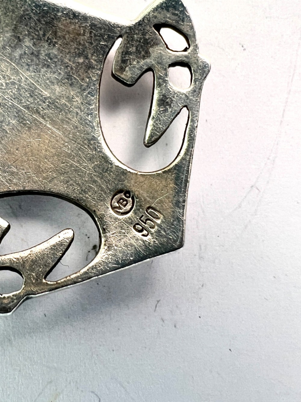 A silver Arts and Crafts style openwork pendant featuring stylised Celtic knots around a central oval blue and green enamel insert. View VIII
