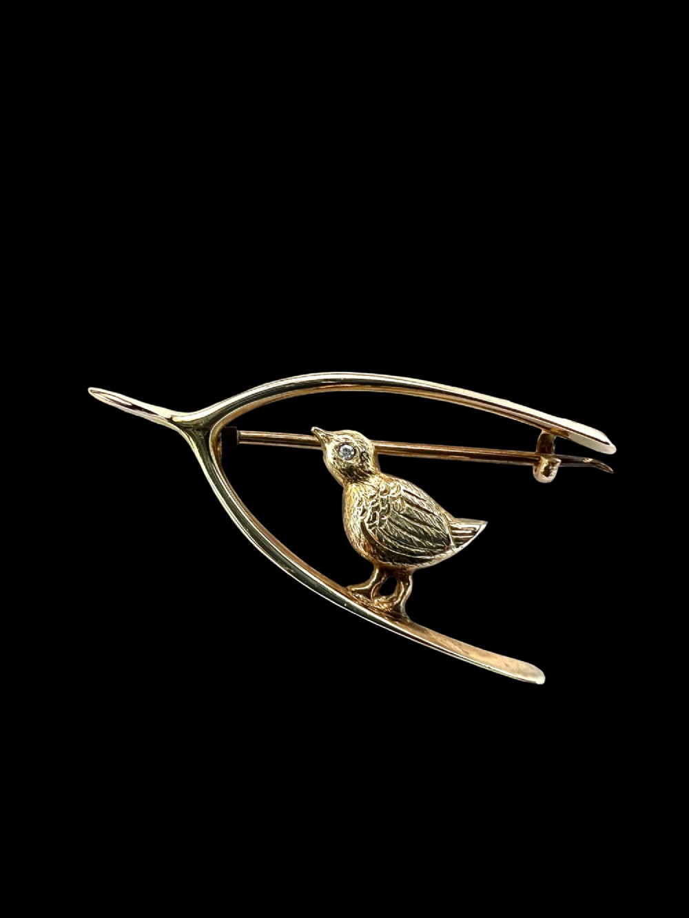 An Edwardian 9ct gold wishbone brooch featuring an engraved chick with a small diamond eye. View III