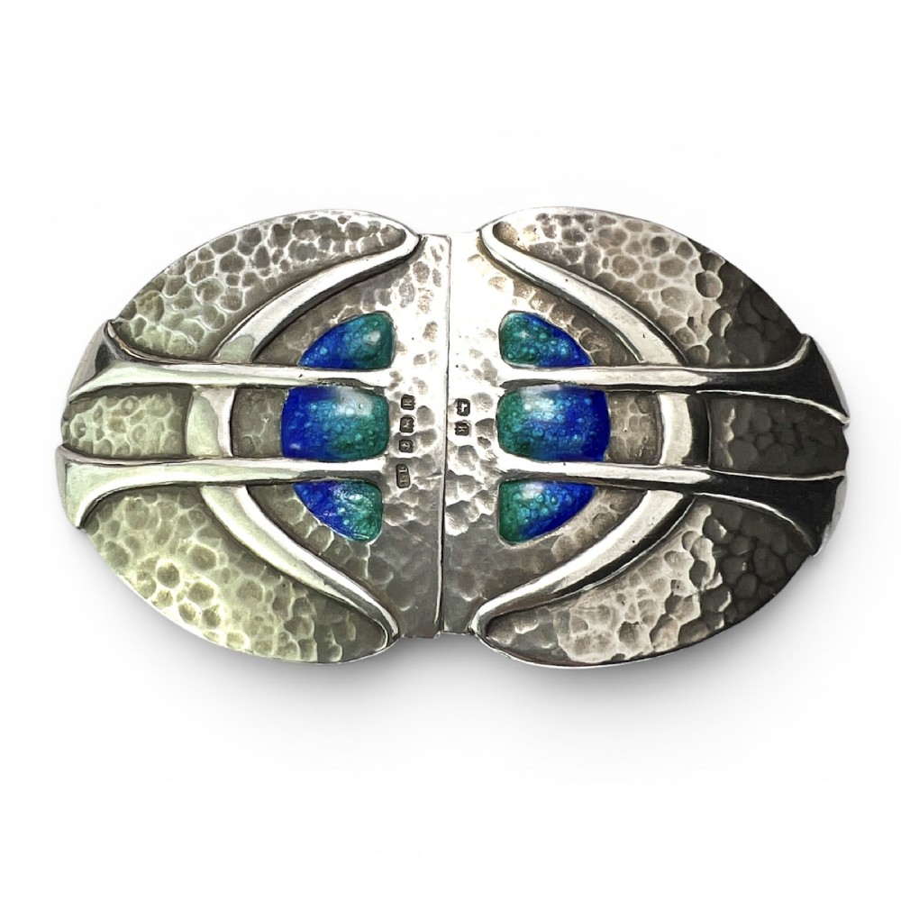 A two-part Art Nouveau sterling silver belt buckle featuring hand-hammered oval surfaces inlaid with vibrant blue and green enamelling and hallmarked in the centre.