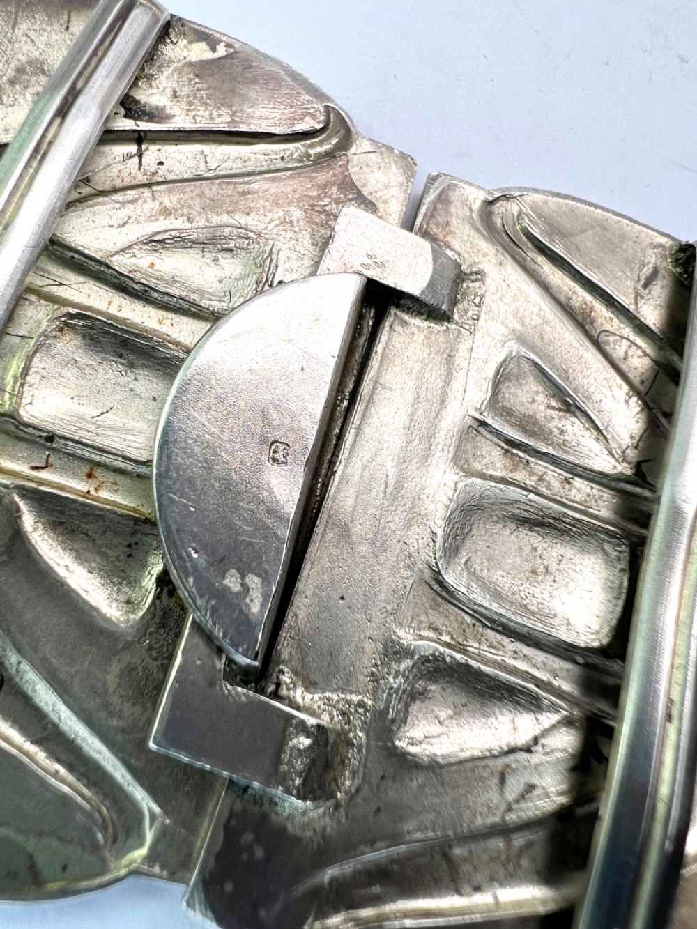 A two-part Art Nouveau sterling silver belt buckle featuring hand-hammered oval surfaces inlaid with vibrant blue and green enamelling and hallmarked in the centre. View VIII