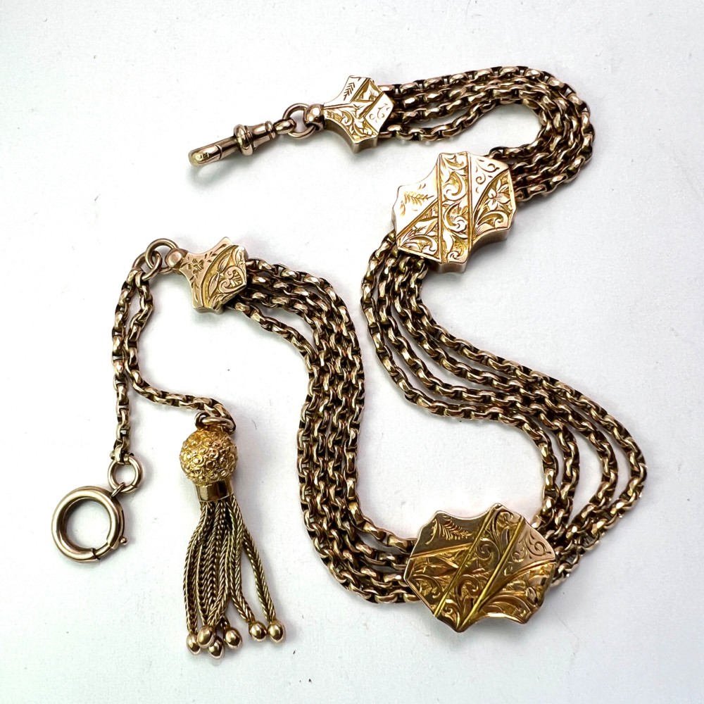 An antique 9ct yellow gold Albertina watch chain featuring four strands, decorative engraved slides, a swivel clasp, and a dangling tassel. View V