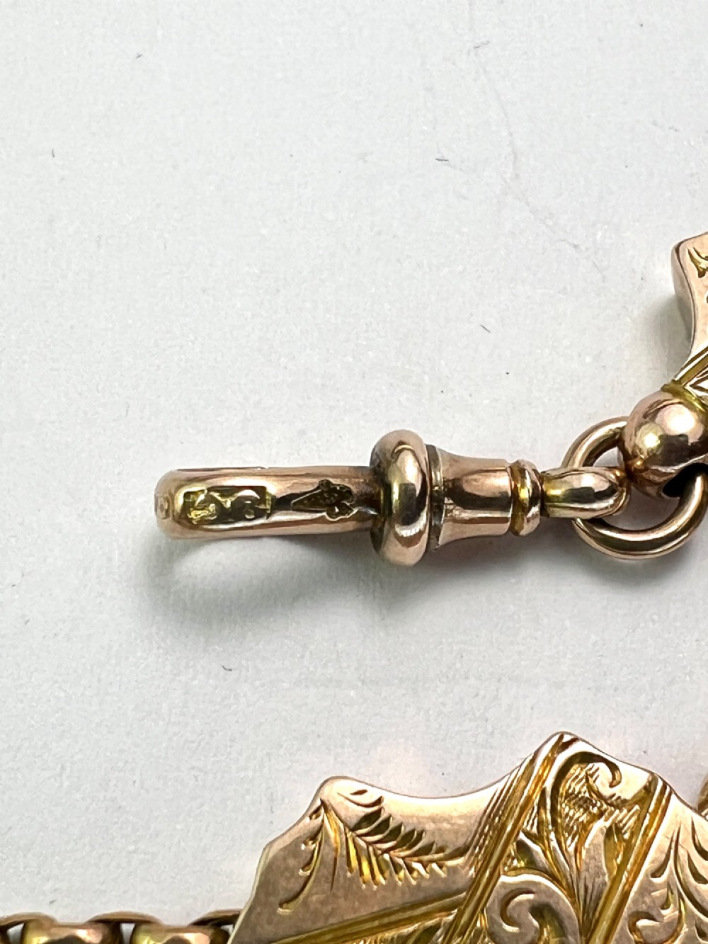 An antique 9ct yellow gold Albertina watch chain featuring four strands, decorative engraved slides, a swivel clasp, and a dangling tassel. View VIII
