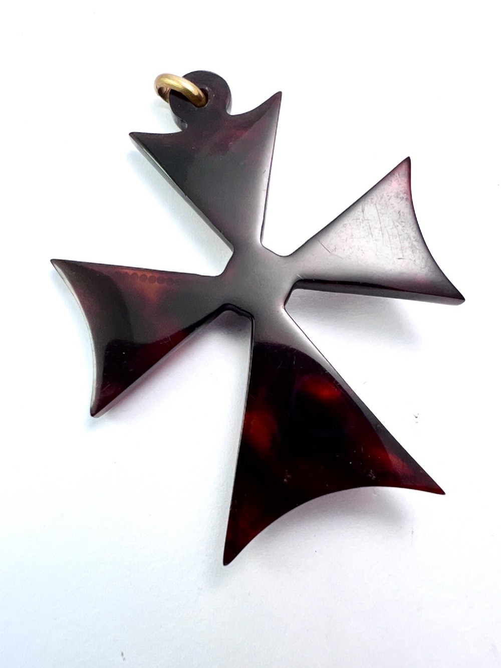 A dark tortoiseshell cross pattee pendant decorated with gold and silver pique inlay of foliate motifs and bordered by silver pinwork with a central black cabochon. View IV