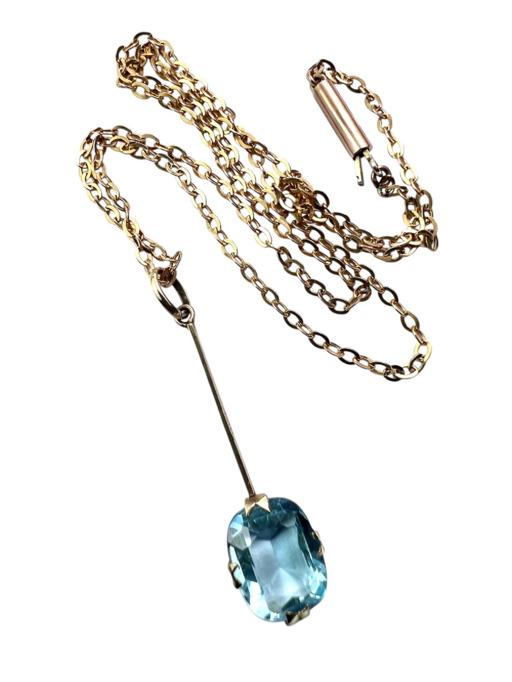 An Edwardian 9ct gold fine chain necklace featuring a linear bar drop suspending a blue paste aquamarine gemstone. View III