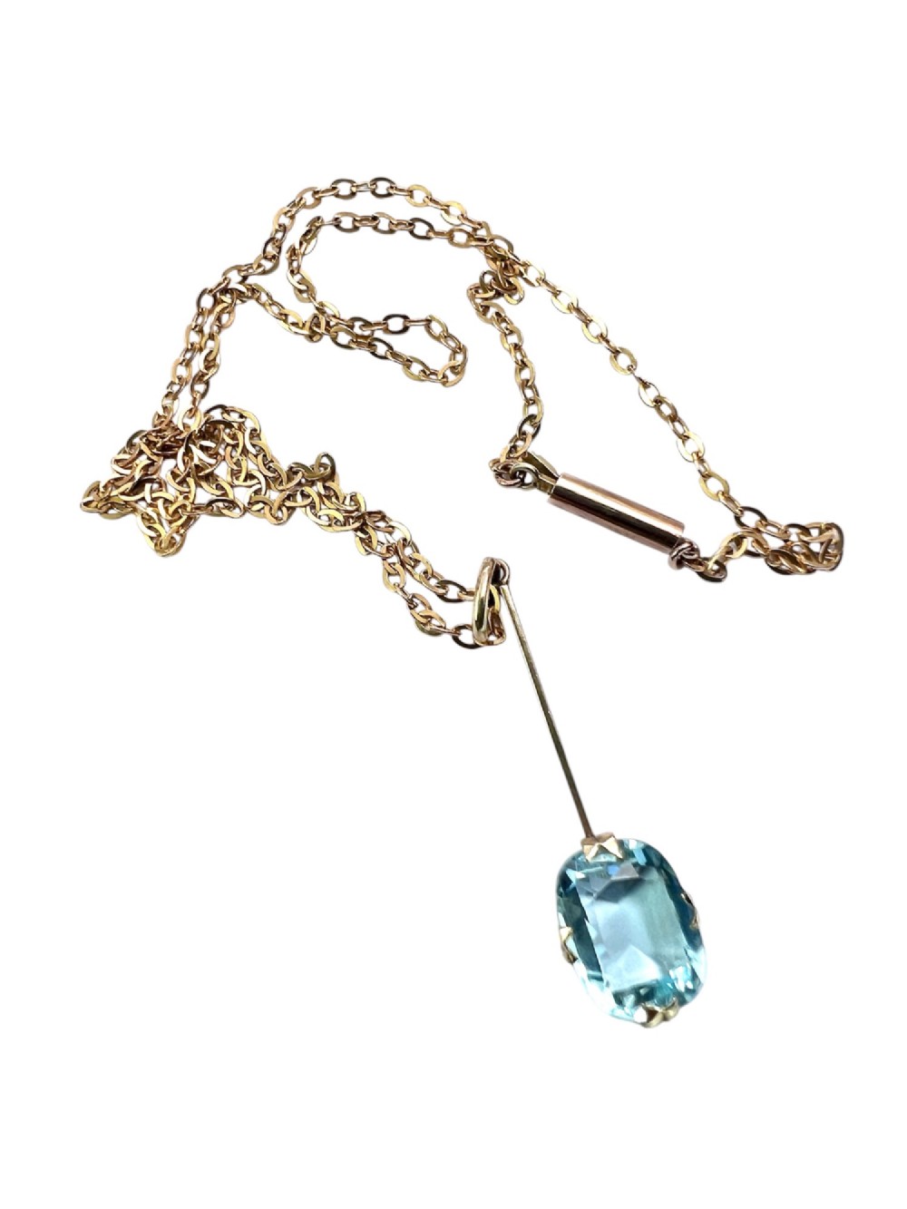 An Edwardian 9ct gold fine chain necklace featuring a linear bar drop suspending a blue paste aquamarine gemstone. View IV