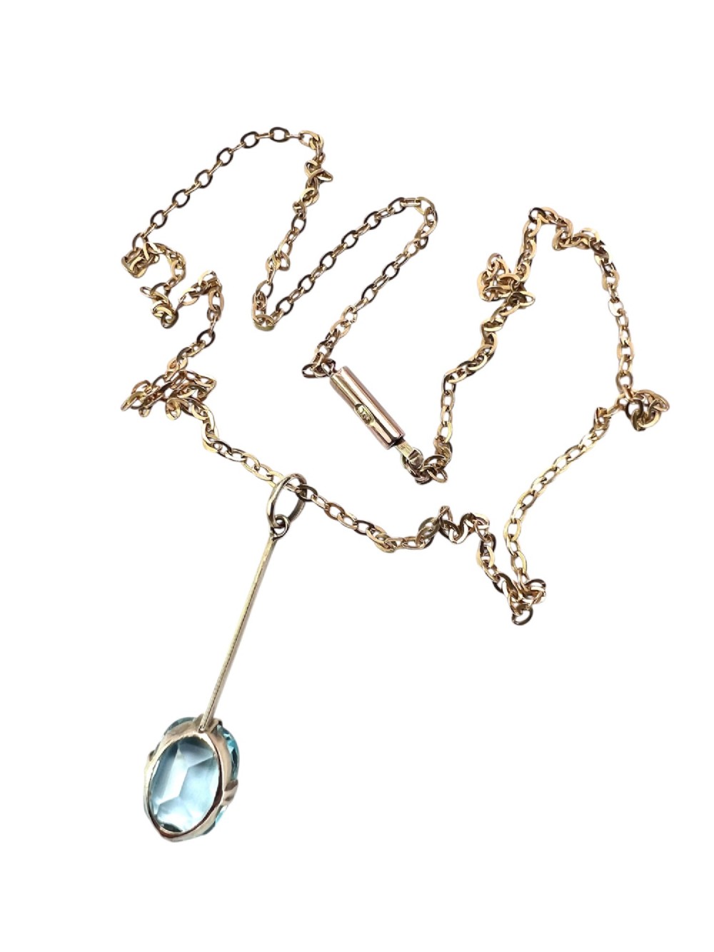 An Edwardian 9ct gold fine chain necklace featuring a linear bar drop suspending a blue paste aquamarine gemstone. View V