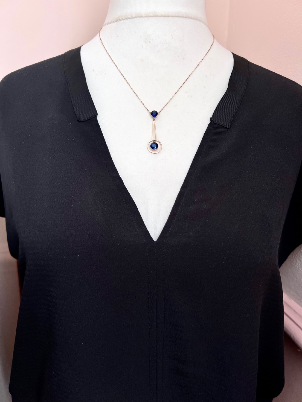 An Edwardian 9ct gold fine chain necklace featuring a geometric drop pendant set with two faceted dark blue paste stones. View VIII