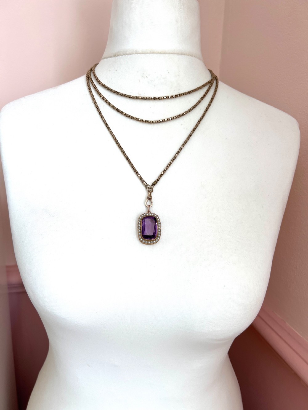 A Victorian rectangular cushion-cut purple paste stone pendant surrounded by a halo of small white seed pearls in a gold mount. View VII