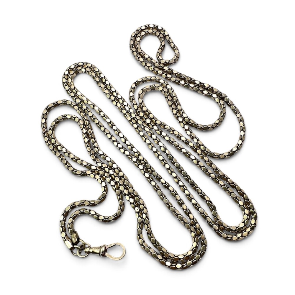 A long yellow gold longuard chain featuring faceted textured links and an Albert swivel clip at the end on a white surface.