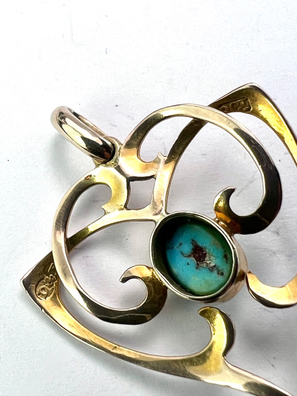 An Art Nouveau 9ct yellow gold openwork heart-shaped pendant set with a central turquoise cabochon and a dangling oval turquoise stone. View II