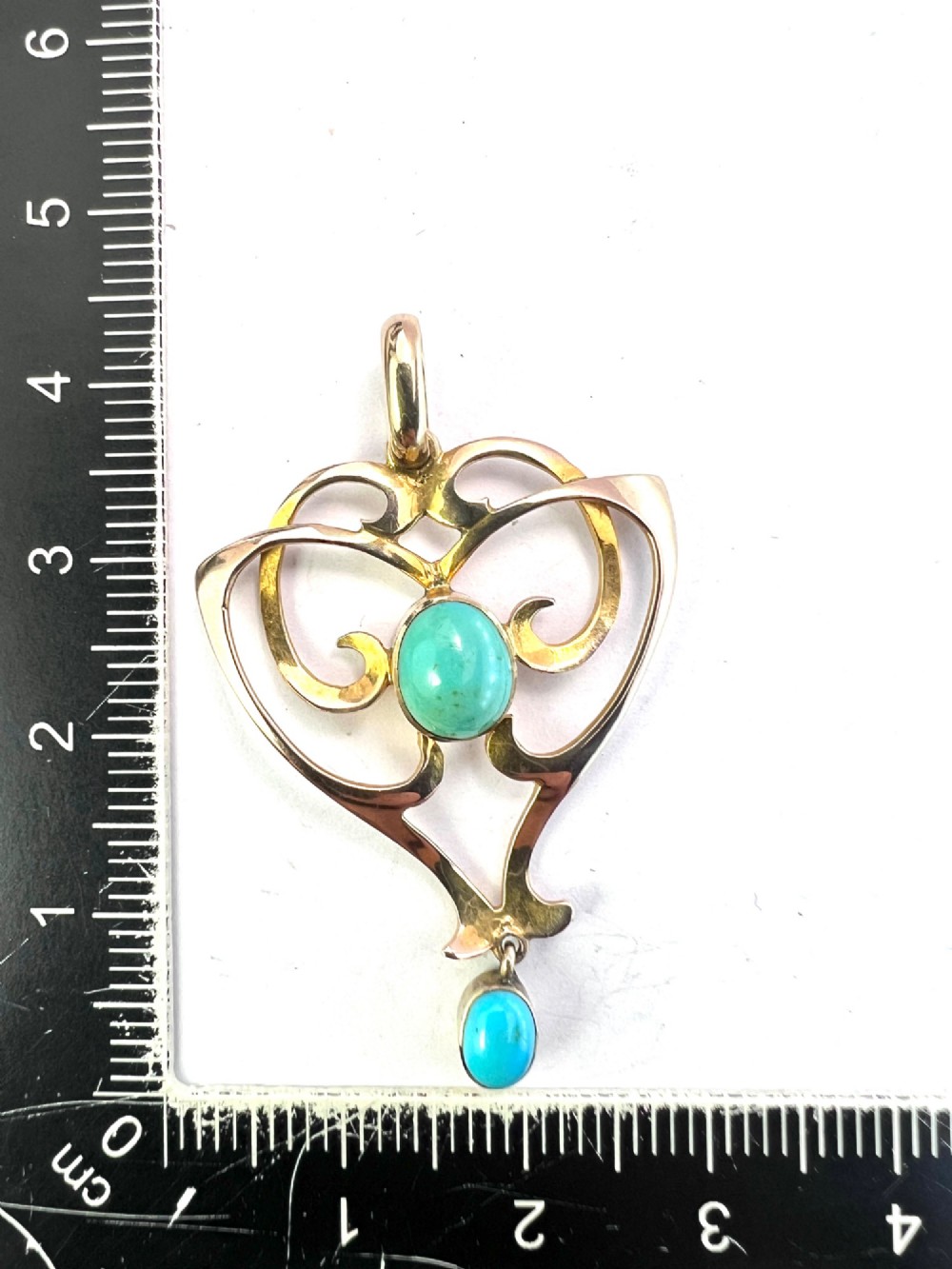 An Art Nouveau 9ct yellow gold openwork heart-shaped pendant set with a central turquoise cabochon and a dangling oval turquoise stone. View III