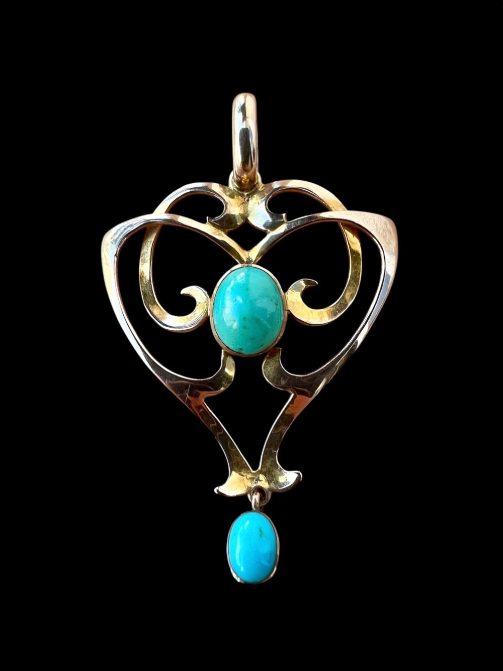 An Art Nouveau 9ct yellow gold openwork heart-shaped pendant set with a central turquoise cabochon and a dangling oval turquoise stone. View IV