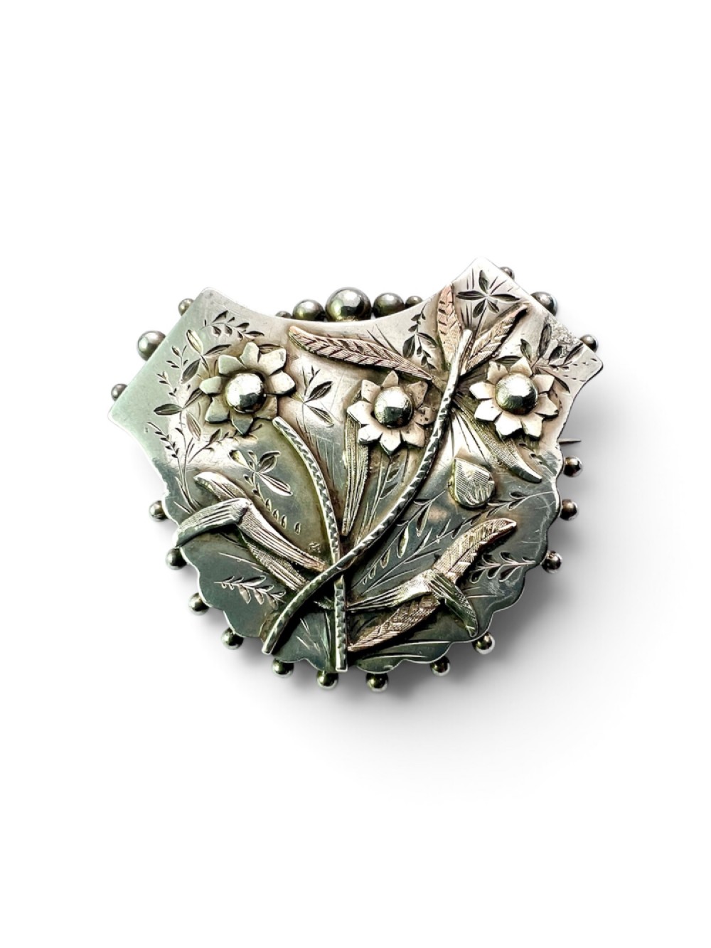 A Victorian silver shield-shaped brooch decorated with applied rose gold flowers, hand engraving, and a beaded outer rim. View III