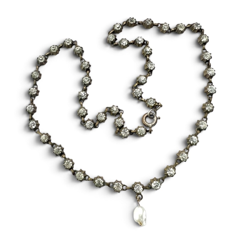 A Victorian silver-tone chain linked with round faceted paste glass stones and featuring a singular natural pearl drop at the centre.