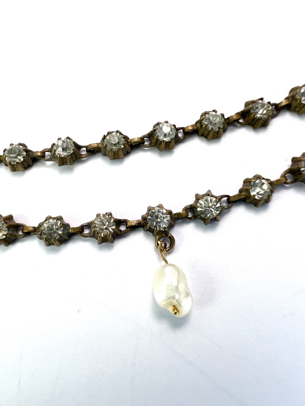 A Victorian silver-tone chain linked with round faceted paste glass stones and featuring a singular natural pearl drop at the centre. View II
