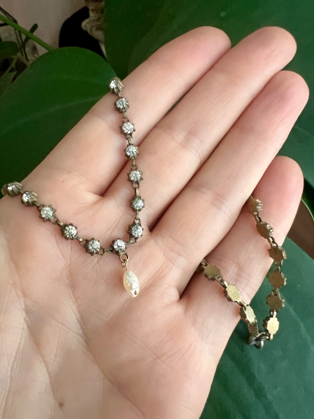 A Victorian silver-tone chain linked with round faceted paste glass stones and featuring a singular natural pearl drop at the centre. View V