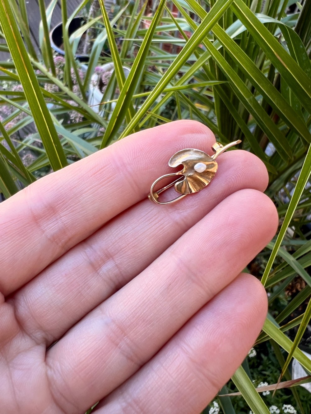 An Art Nouveau gold bar brooch shaped as a lily pad leaf holding a central cream pearl. View VIII