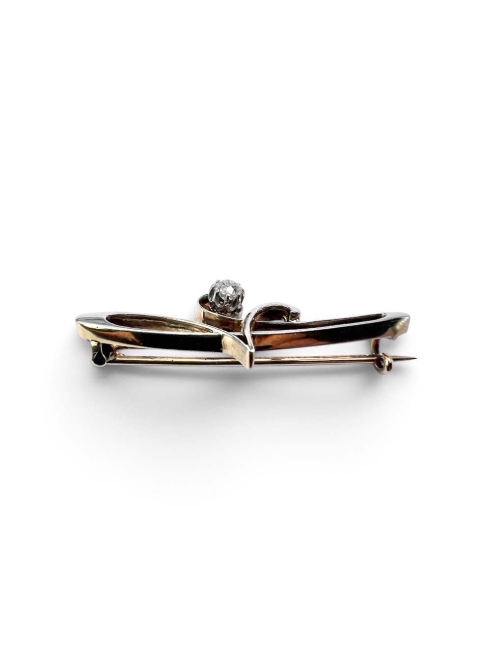 An Art Nouveau 15ct gold and platinum brooch featuring a central diamond set within fluid curvilinear metalwork, presented inside a fitted burgundy velvet box. View III