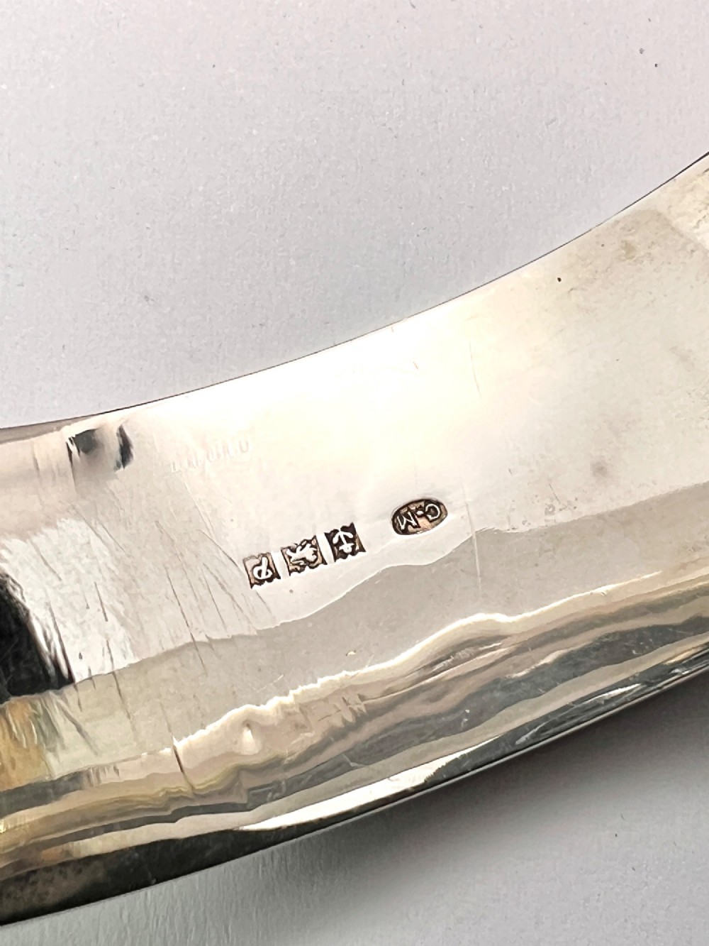 A wide sterling silver hinged bangle featuring detailed hand-engraved scrollwork and a polished inner finish. View VII
