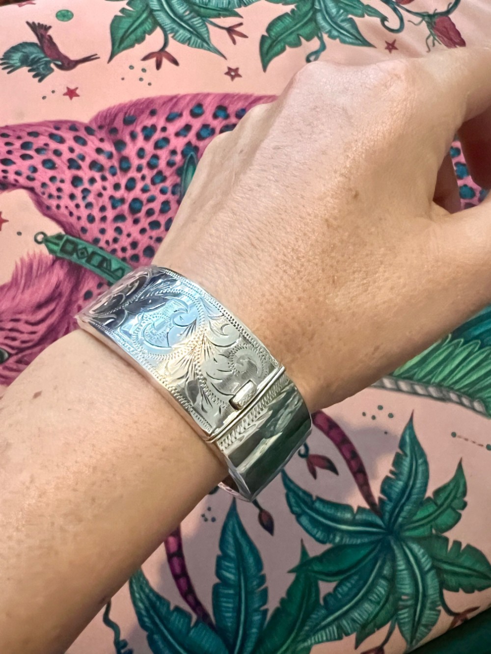 A wide sterling silver hinged bangle featuring detailed hand-engraved scrollwork and a polished inner finish. View VIII