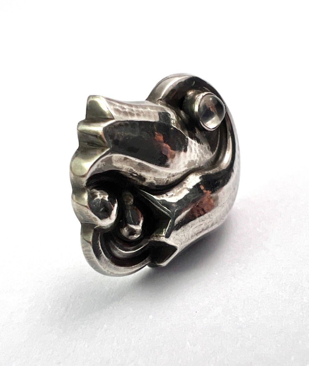 A single sterling silver stud earring shaped as a stylized tulip blossom with an inset round moonstone cabochon near the scroll base. View III