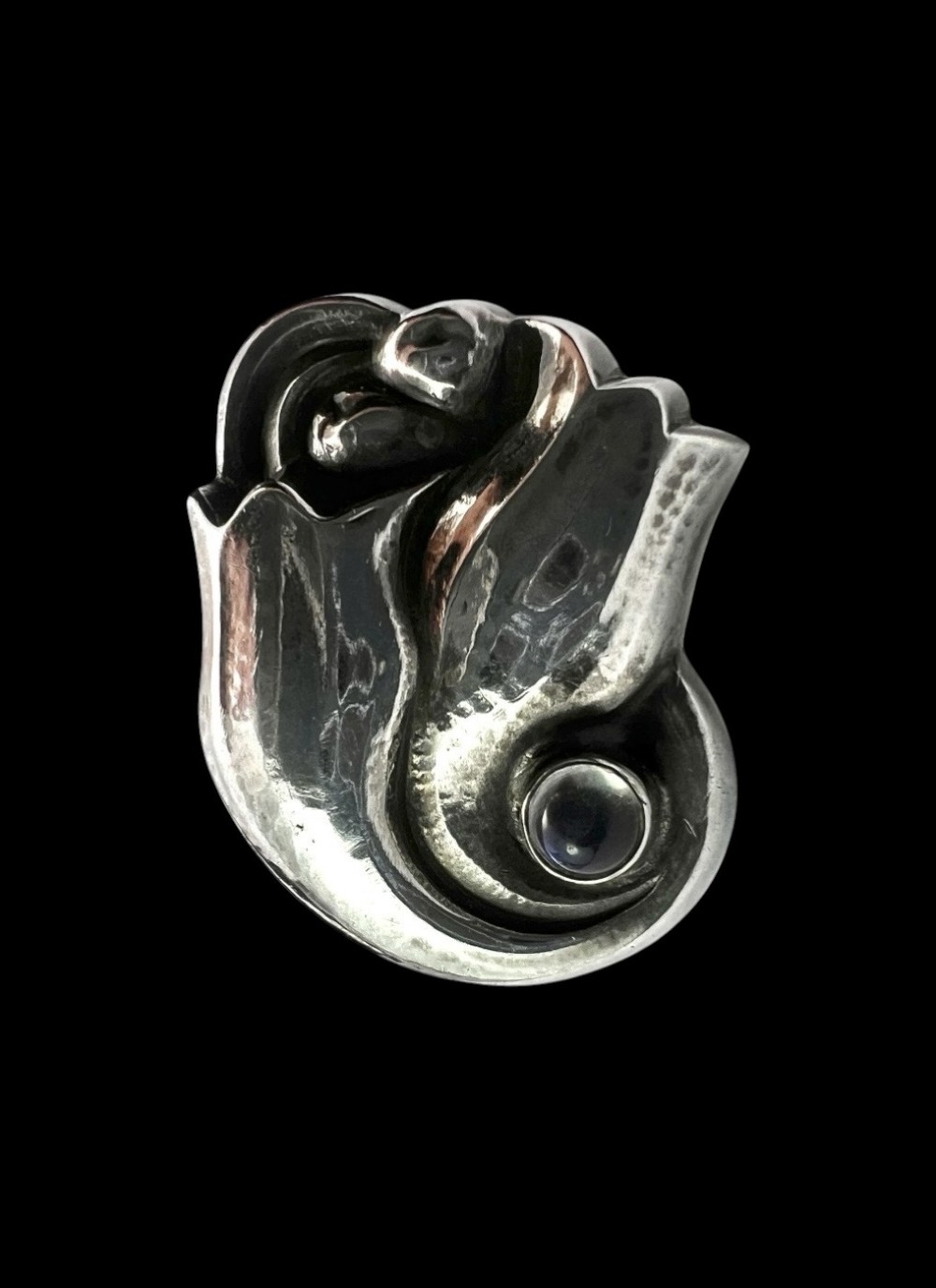 A single sterling silver stud earring shaped as a stylized tulip blossom with an inset round moonstone cabochon near the scroll base. View VII