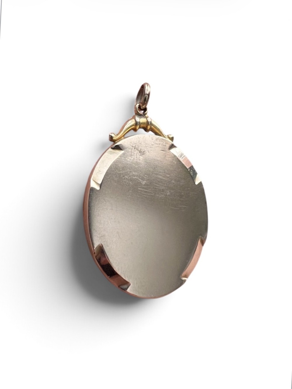 An oval 9ct yellow gold Victorian locket decorated with foliate engraving and inlaid with rubies and seed pearls. View III