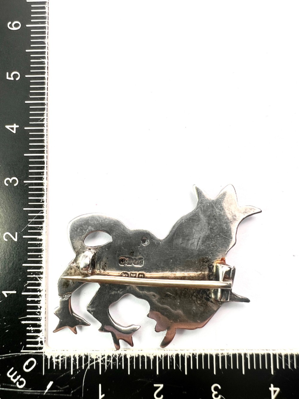 A cast sterling silver brooch shaped like a crowned heraldic lion in raised relief. View IV