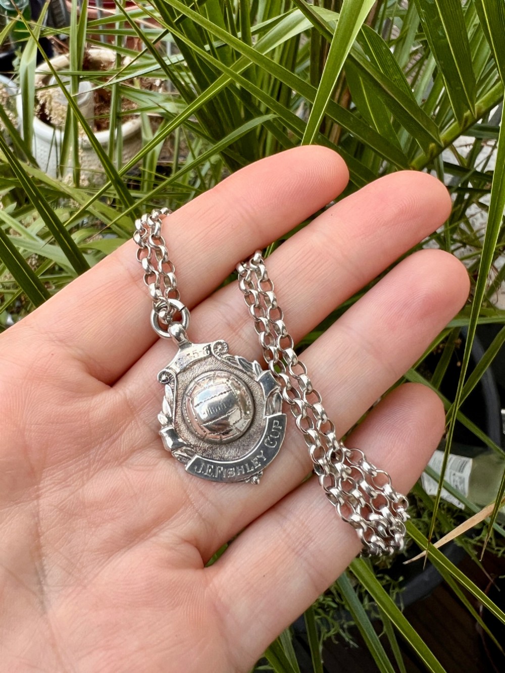 A sterling silver chain necklace featuring a shield-shaped football medal pendant engraved with 1945-6 and JR Fishley Cup. View III