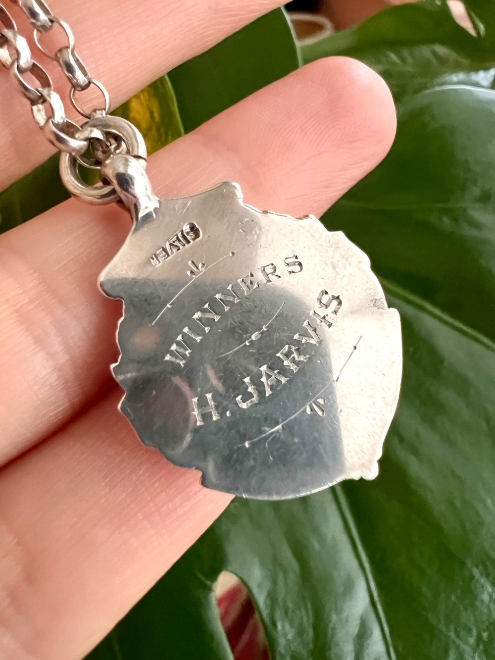 A sterling silver chain necklace featuring a shield-shaped football medal pendant engraved with 1945-6 and JR Fishley Cup. View VI