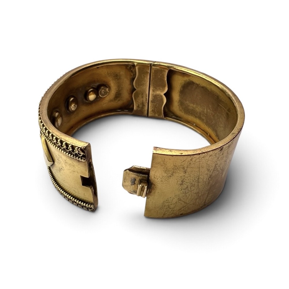 A wide Victorian Etruscan Revival gold hinged bangle decorated with intricate beadwork borders and star-set gemstones across a central band. View VII