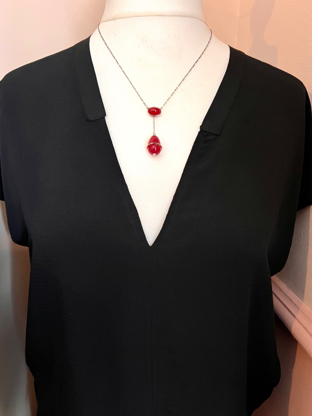 An Edwardian silver lavalier necklace featuring an oval red stone cabochon and an egg-shaped red pendant bound by a silver band. View VIII