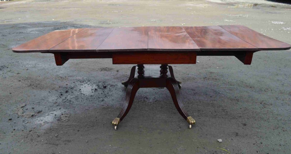 A Late Georgian Drop leaf extending mahogany dining table