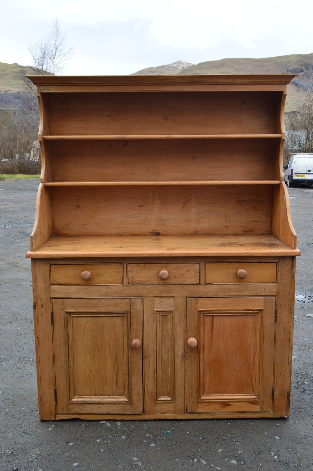 A Victorian Scots pine dresser featuring an upper open-shelf display rack above a base with three drawers and lower double cupboard doors. View III