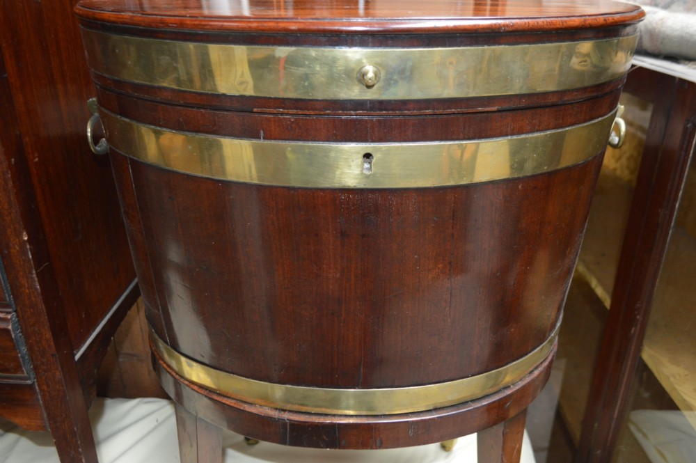 An 18th-century George III oval mahogany wine cooler with polished brass bindings and tapered legs on castors. View VI