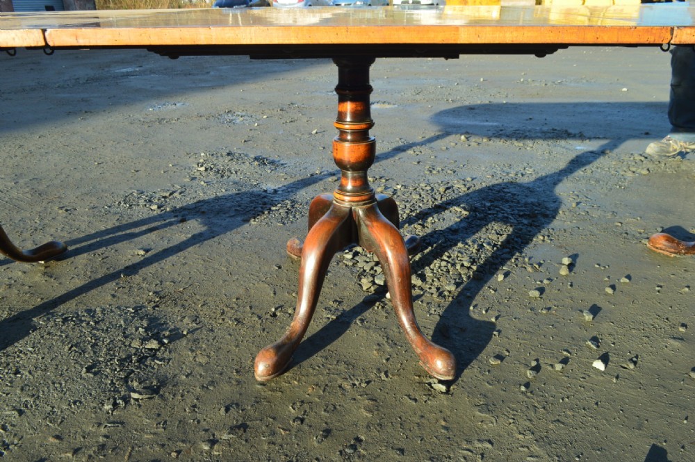 A George III style extendable dining table made of figured walnut with three turned pedestal bases and tripod legs. View III