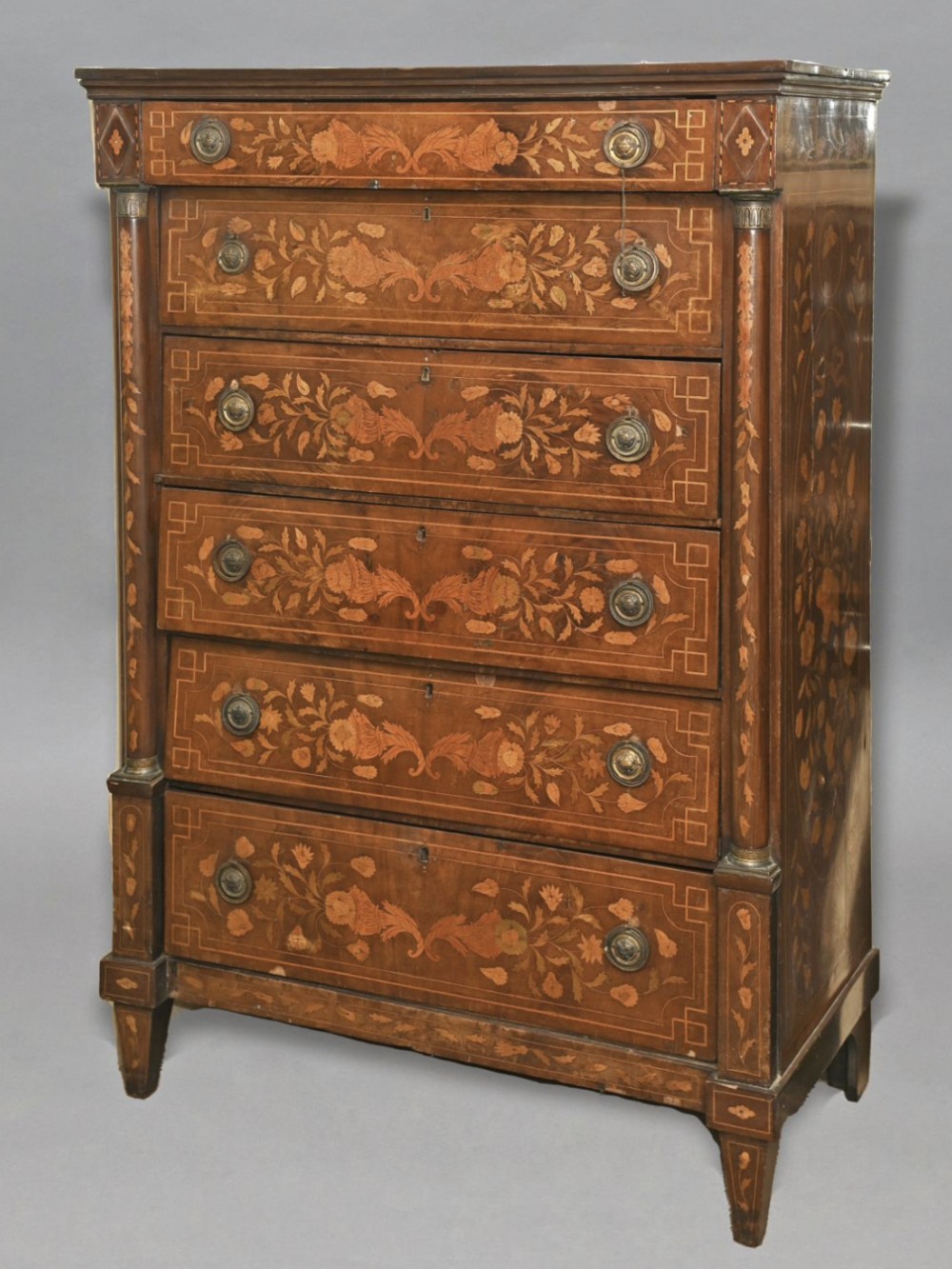 An eighteenth-century Dutch tallboy chest of drawers made from dark walnut wood featuring floral marquetry inlays, six drawers with brass handles, and tapered square legs.