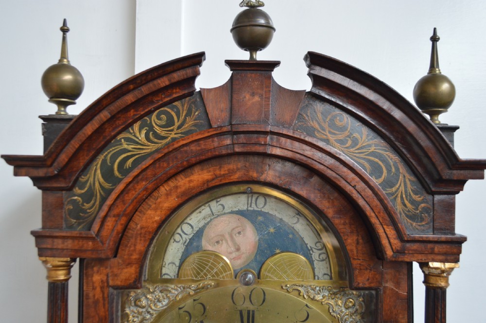 An 18th-century pollard oak longcase clock with an arched hood, brass eagle finial, and engraved brass dial. View III