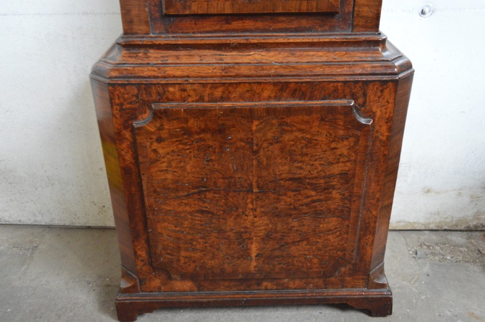 An 18th-century pollard oak longcase clock with an arched hood, brass eagle finial, and engraved brass dial. View VI
